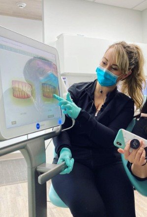 Dental team member pointing to digital impressions