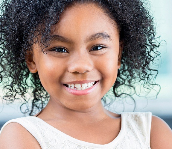 Child with healthy smile thanks to tooth colored fillings