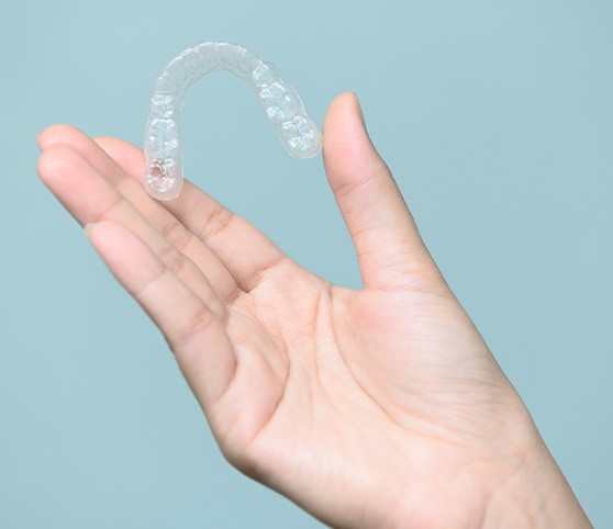 Closeup of patient holding clear aligner