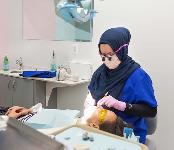 Dental team member treating dental patient