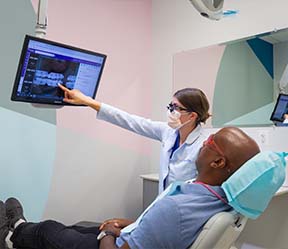 Dental team member and patient looking at x-rays together
