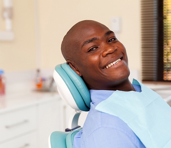 Blonde woman in dental chair looking back and smiling