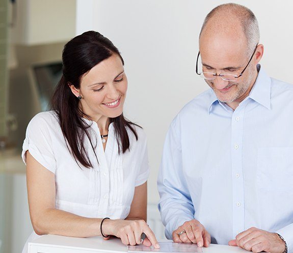 Dental team member and patient discussing the cost of dental implants