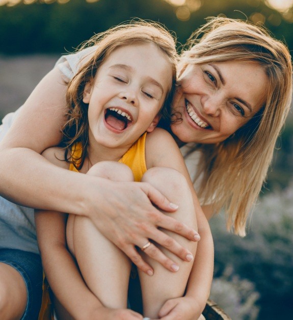 Mother hugging laughing child