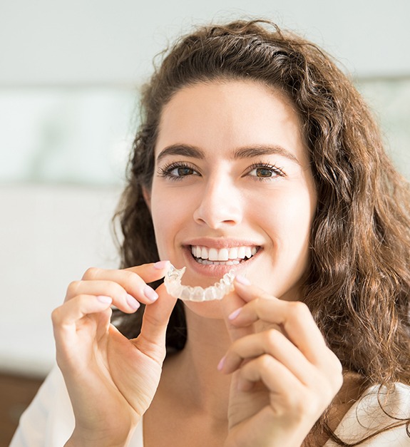 Woman placing Invisalign clear braces tray