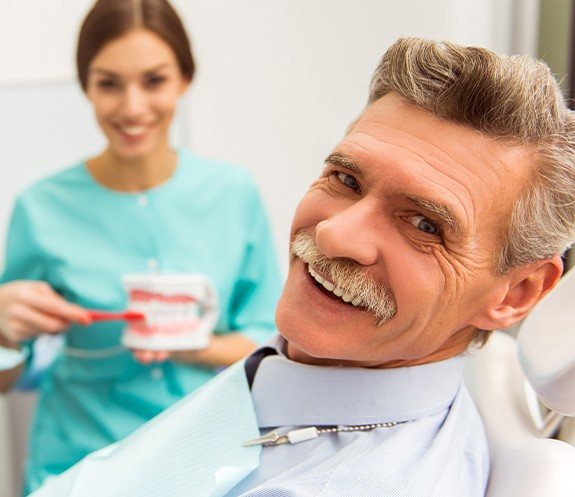 Man in dental chair smiling during treatment for gingivitis