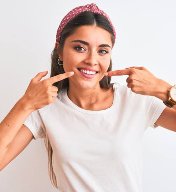 Happy woman pointing at her healthy smile