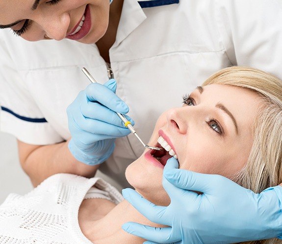 Dentist performing oral cancer screening