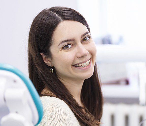 Woman smiling after same day dental crown restoration