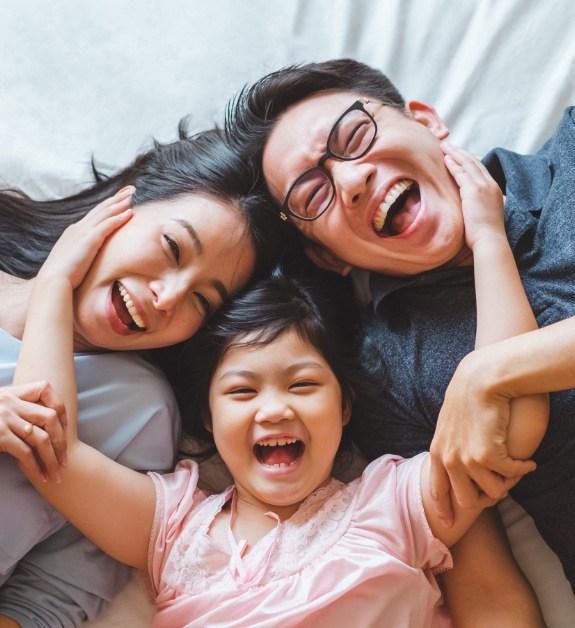 Family smiling together after receiving dental services