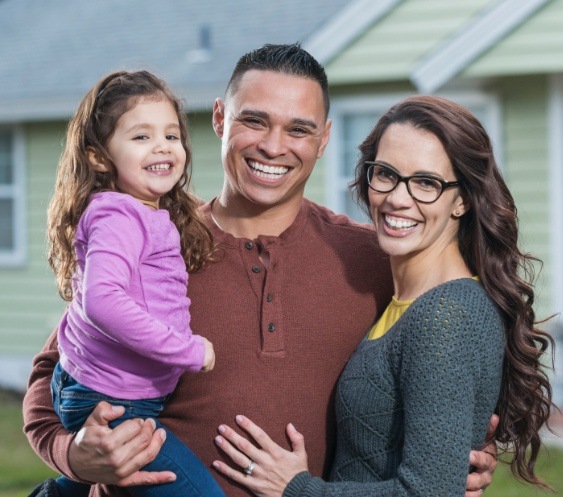 Family smiling together after children's dentistry visit