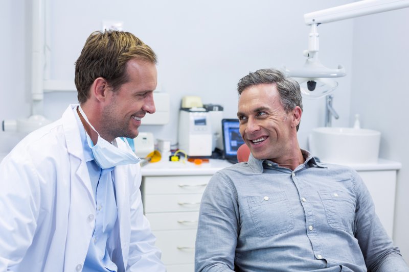 patient smiling while talking to dentist  