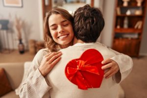 a couple hugging after giving Valentine's Day gifts to each other