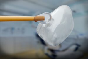 closeup of a single veneer about to be paced on a tooth