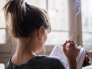 Woman smoking cigarette while reading.